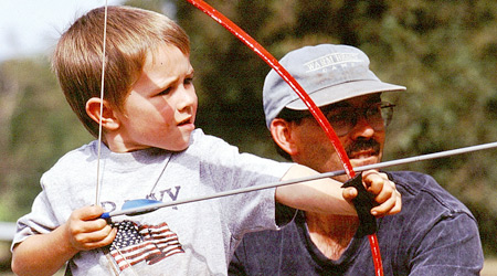 Pat and his son, Kaleb age 5, shooting archery at their first Dad and Sons Weekend